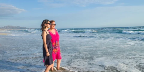 Two women gazing at the sea, enjoying the view together.