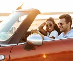 A couple enjoying a scenic drive in a convertible car