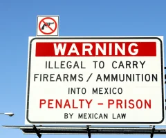 A warning sign displaying the message that it is illegal to cross arms into Mexico.