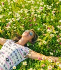 A woman lying peacefully in a field of grass, enjoying the outdoors