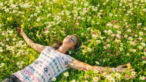 A woman lying peacefully in a field of grass, enjoying the outdoors