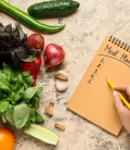 A to-do list placed next to a variety of fresh vegetables on a countertop