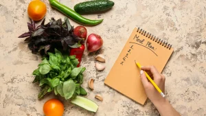 A to-do list placed next to a variety of fresh vegetables on a countertop