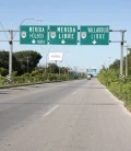 A road in Mexico with signs pointing to Mérida, Valladolid, and Holbox