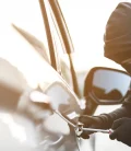 A person attempting to break into a car, showcasing the importance of vehicle security.