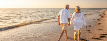 Una pareja felizmente caminando en una playa mexicana