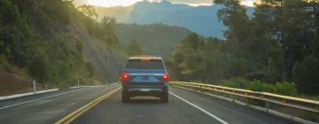 A SUV driving down a scenic road