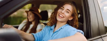 Two girls happily driving excited for the journey ahead