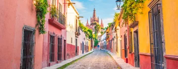 A colorful street in San Miguel de Allende with the cathedral in the background